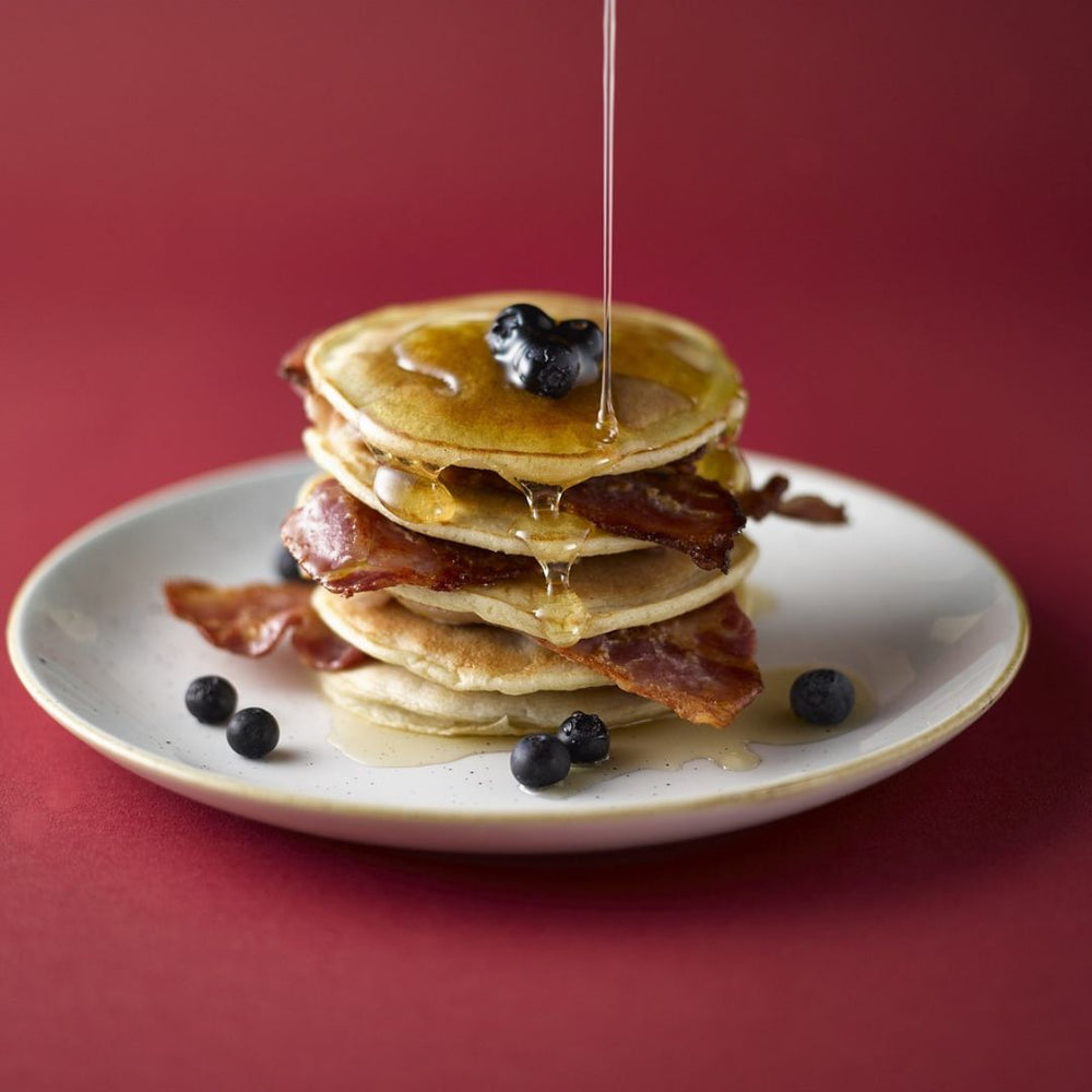 buttermilk pancakes on a plate with syrup and bacon